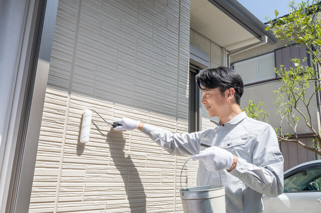 外壁を塗装する男性